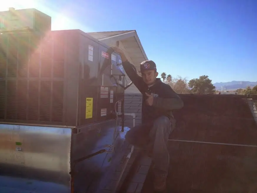 HVAC technician performing HVAC Inspection on a rooftop unit in Alpharetta